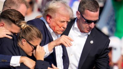 Republican presidential candidate former President Donald Trump is helped off the stage at a campaign event in Butler, Pa., on Saturday, July 13, 2024. (AP Photo/Gene J. Puskar)